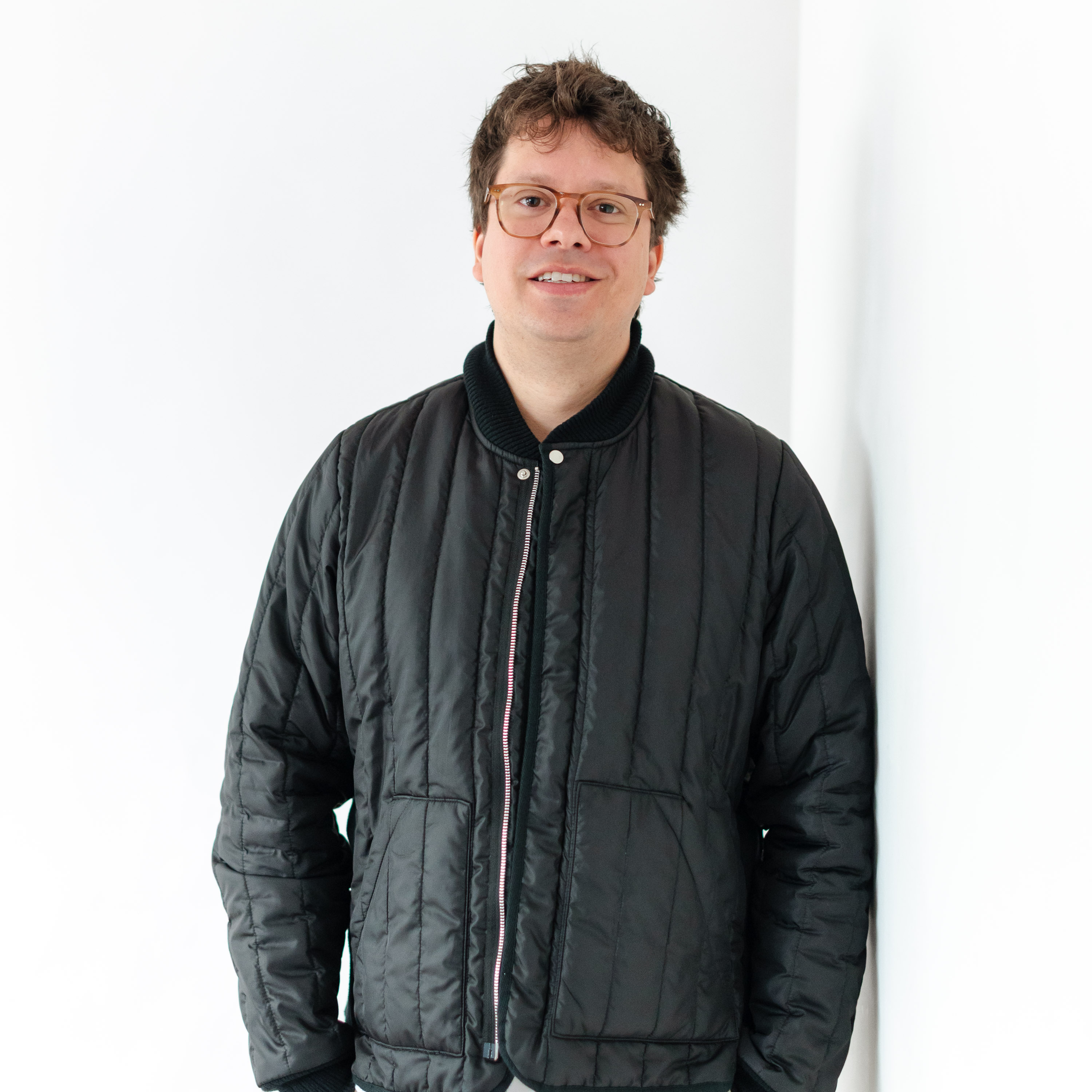 a man wearing glasses and a black jacket