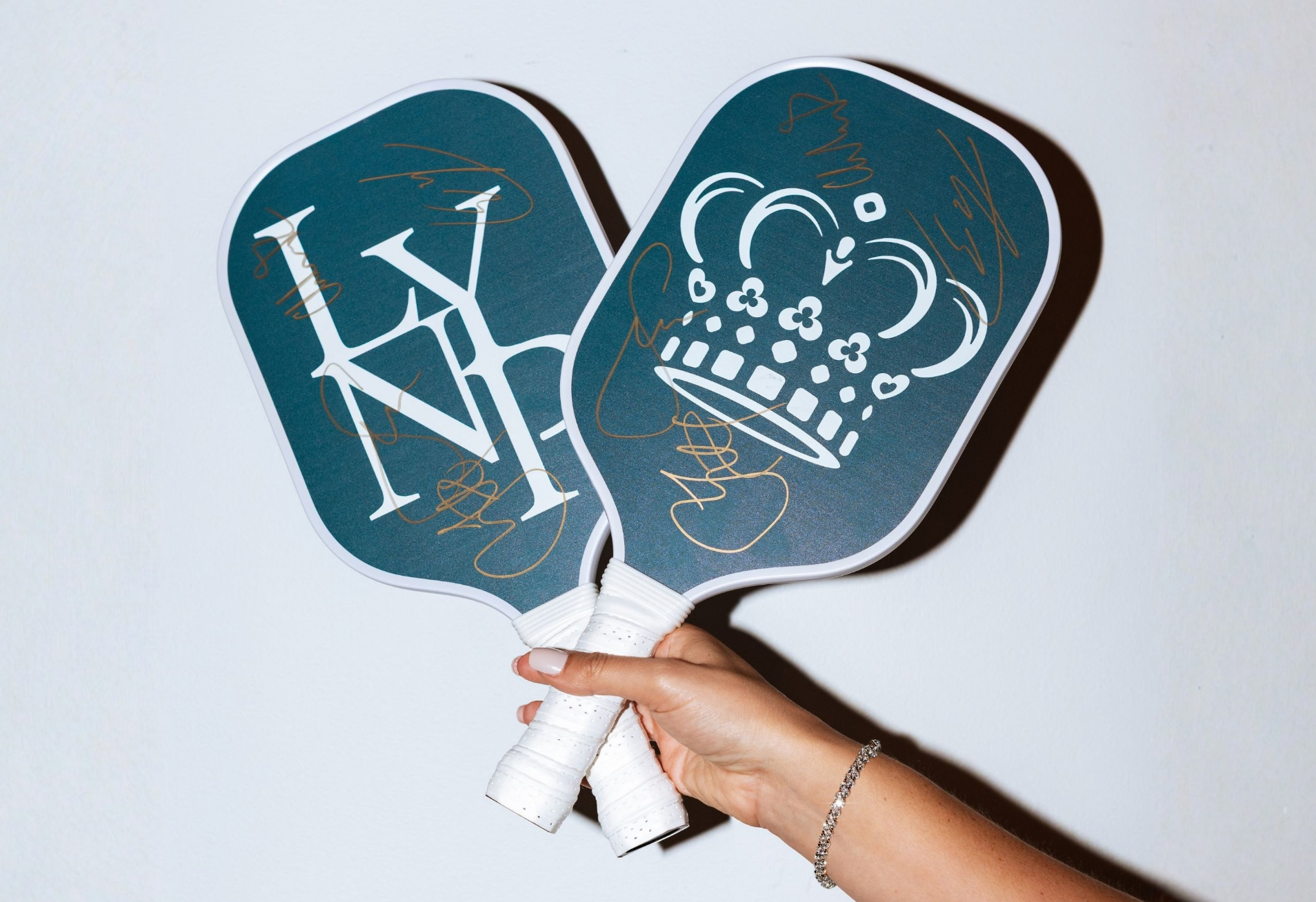 a hand holding paddles with a crown and crown on them