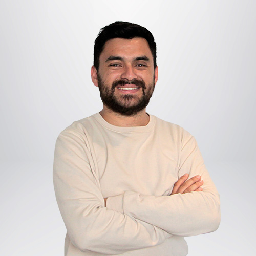 a man with beard and mustache smiling with arms crossed