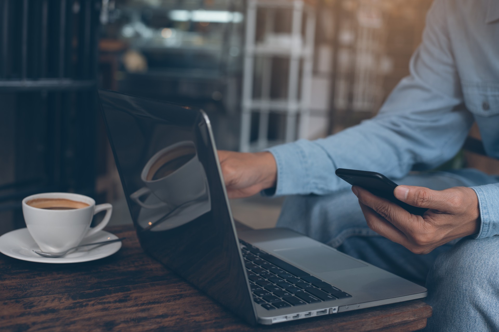 a person using a laptop and a phone