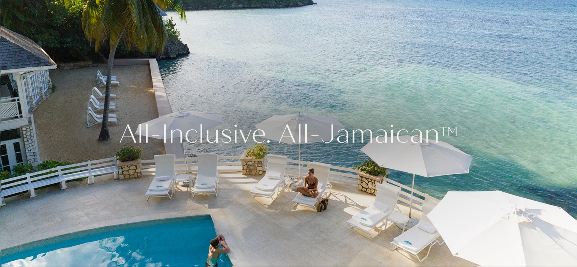 a woman sitting on a deck chair next to a pool