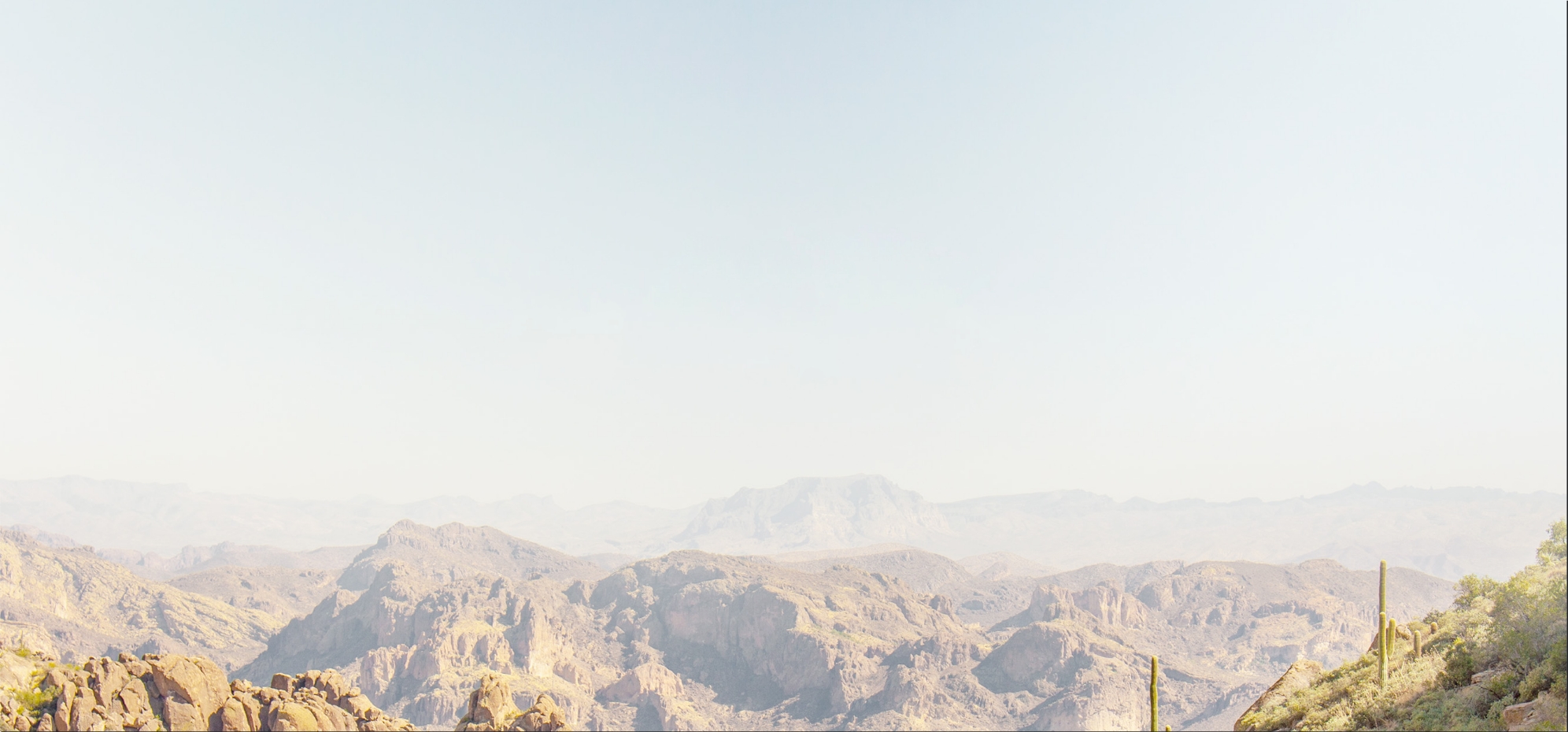 a rocky mountains with a blue sky