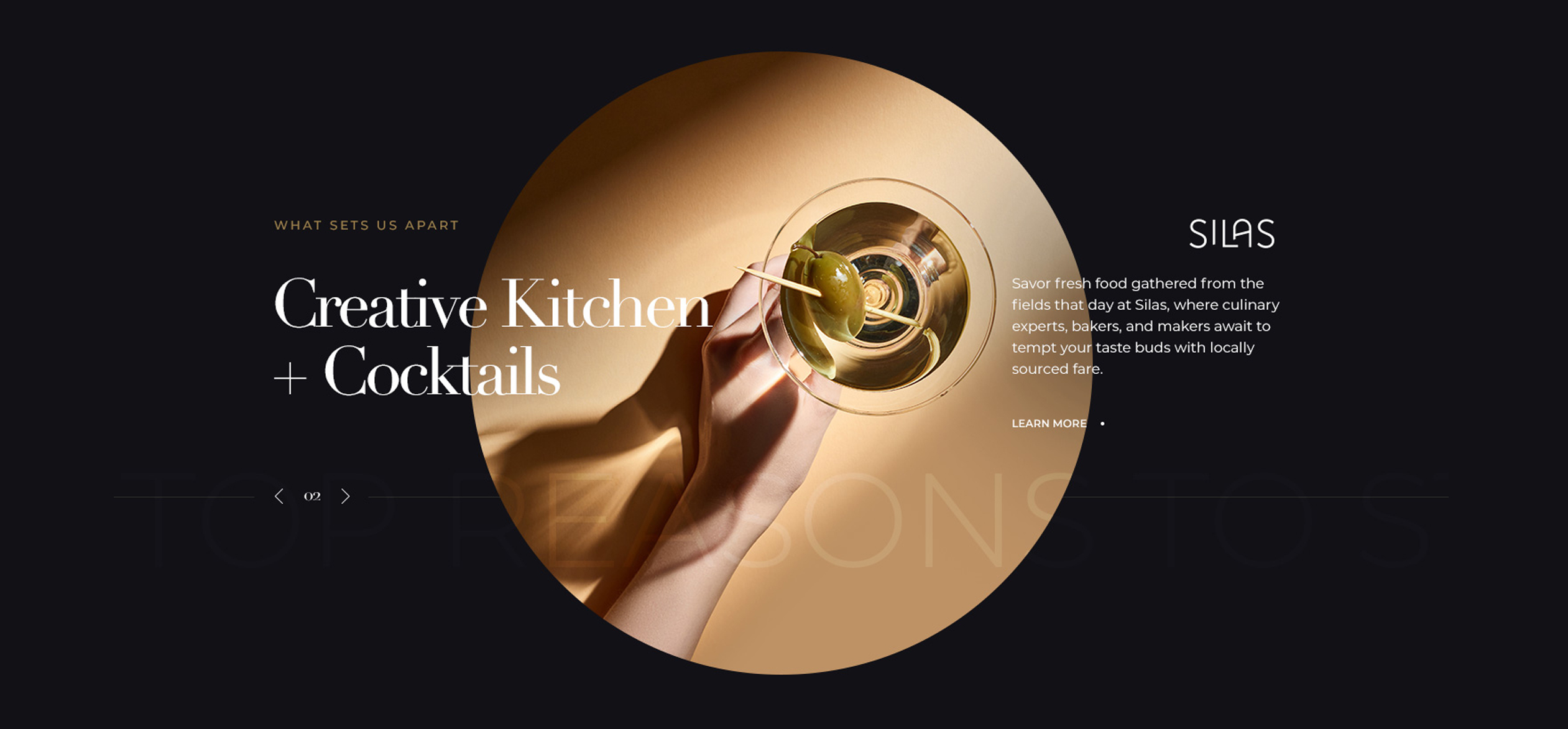 a hand holding a martini glass with a green olive on it