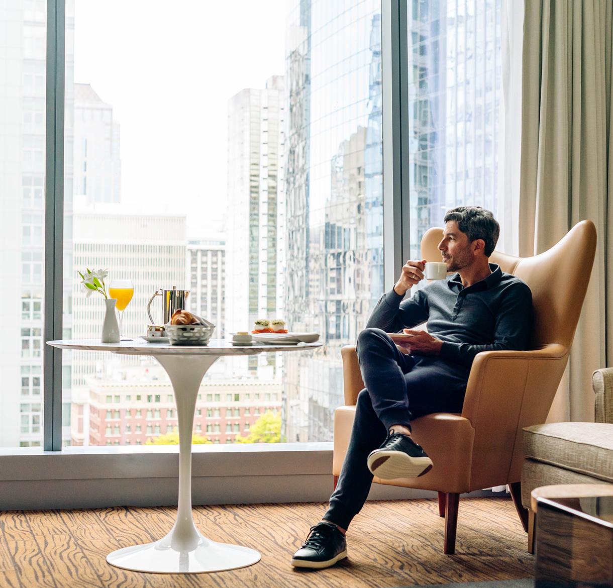 a man sitting in a chair with a cup of coffee