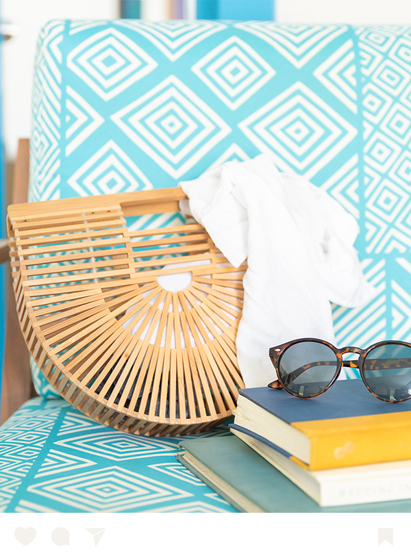 a pair of sunglasses next to a book and a purse