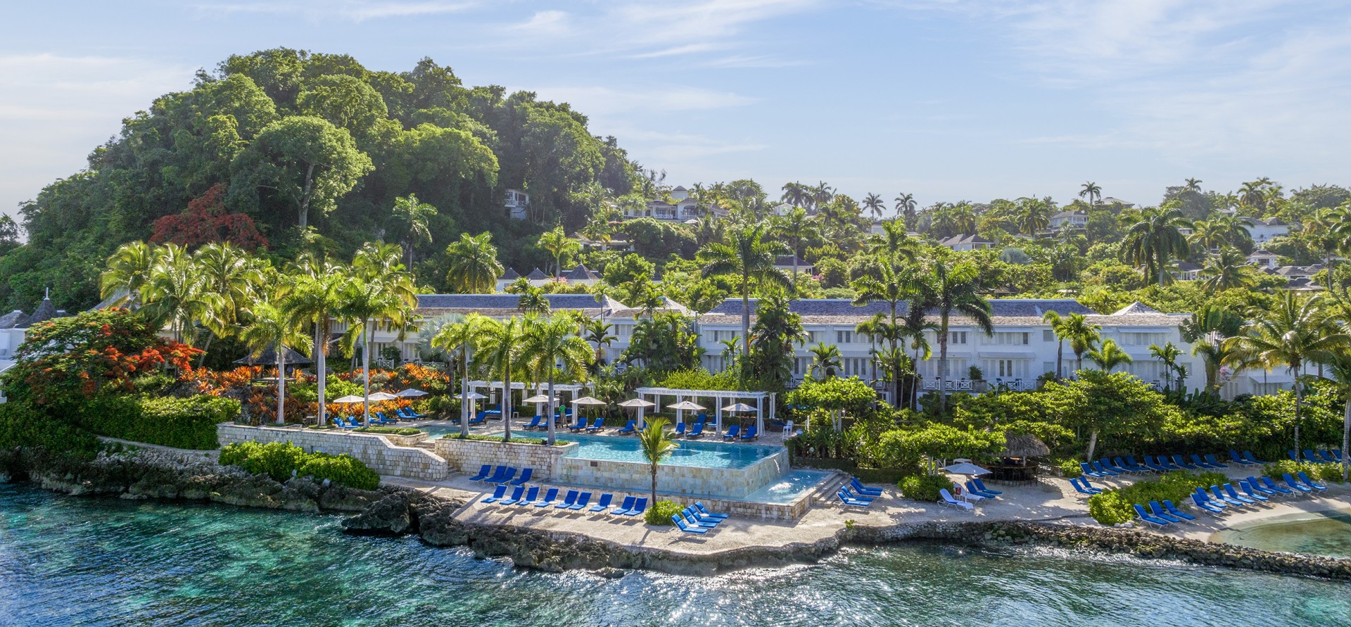 a swimming pool with chairs on the side of a body of water