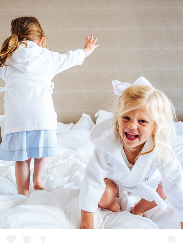 two girls in white robes on a bed
