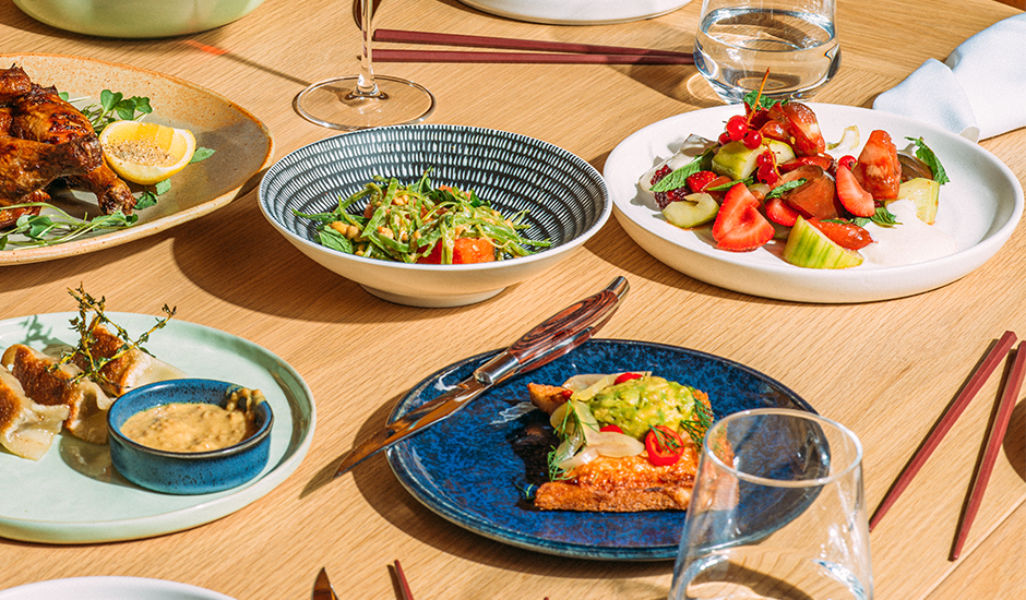 a table with plates of food and glasses Next