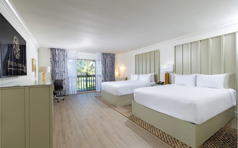 a room with two beds and a desk