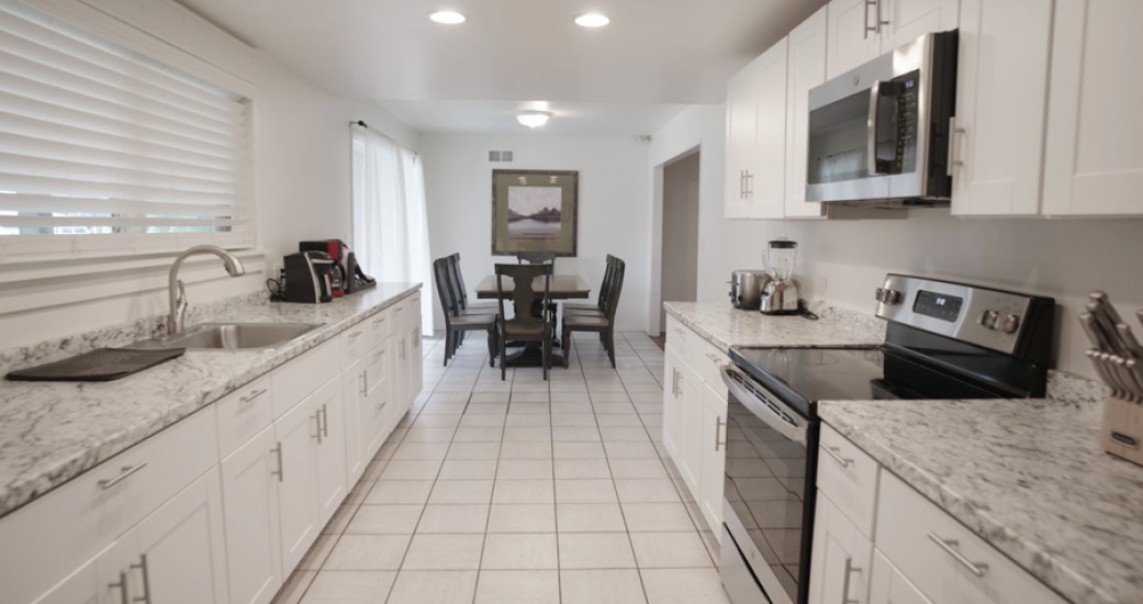 a kitchen with white cabinets and a table