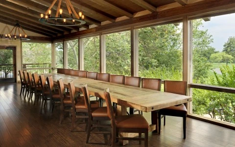 a large table with chairs in a room with windows