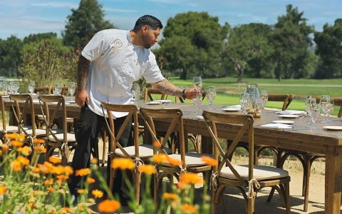 a man standing at a table with wine glasses