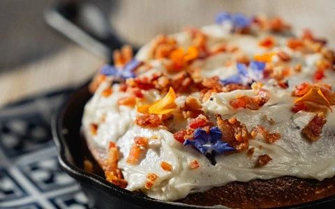 a pan of food with frosting and bacon