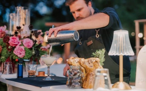 a man pouring a drink into a glass