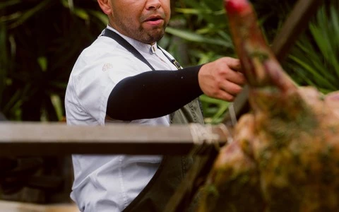 a man holding a meat on a stick
