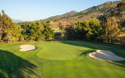 a golf course with sand bunkers and trees