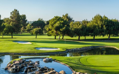 a golf course with a river and trees