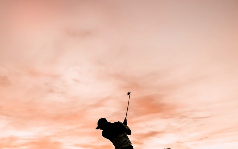 a person swinging a golf club