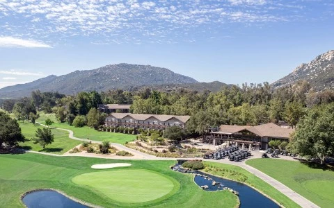 a golf course with a lake and a building