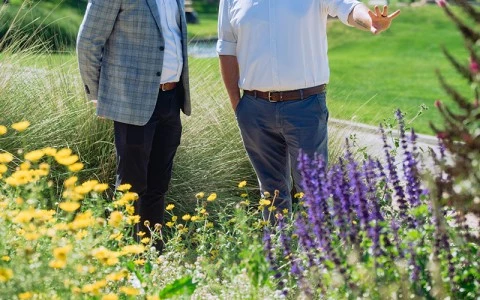 two men walking in a field of flowers