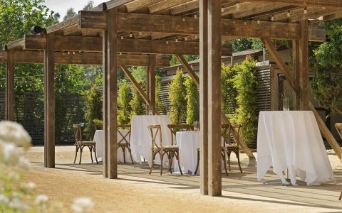 a table and chairs under a wooden structure
