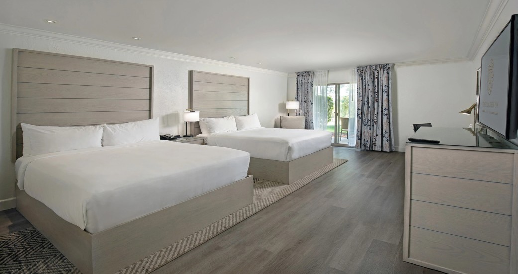 a room with two beds and a wood floor