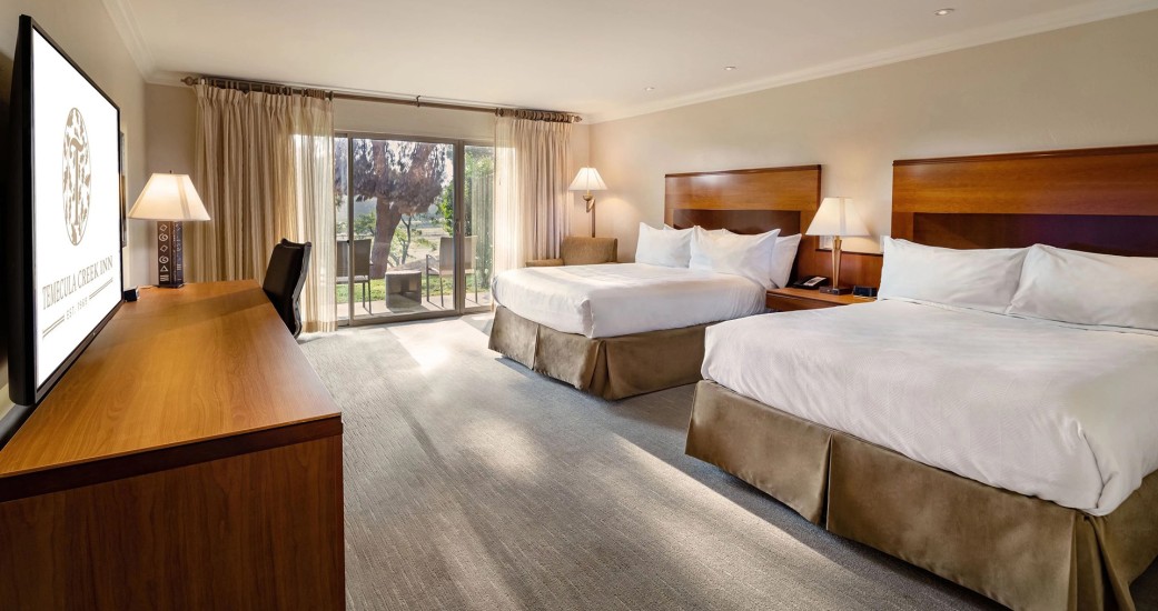 a room with two beds and a desk
