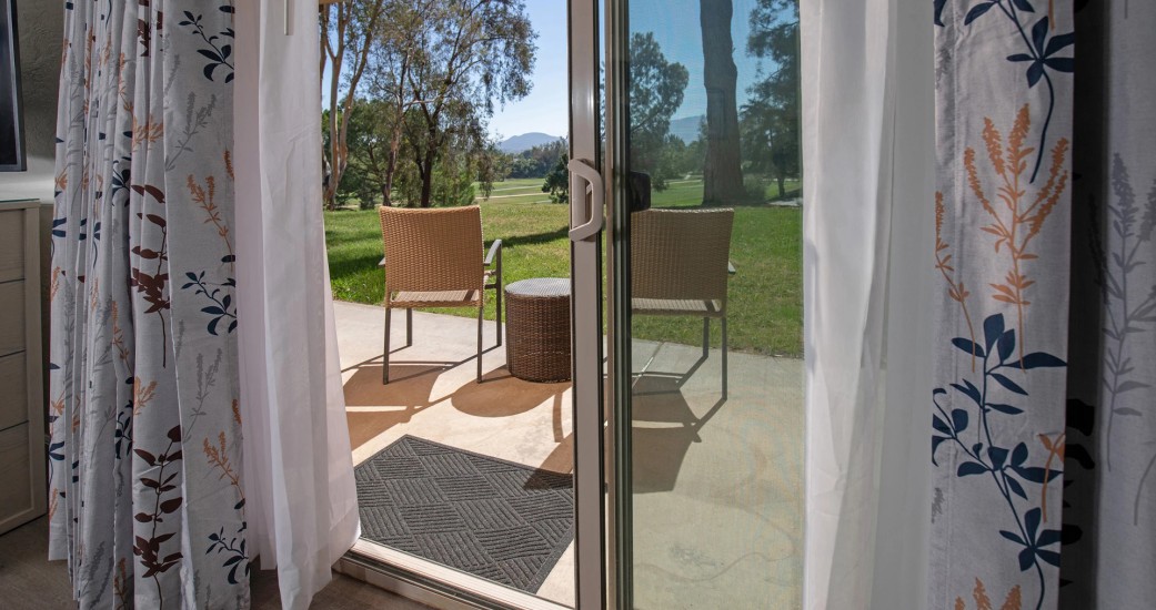 a sliding glass door with a table and chairs outside