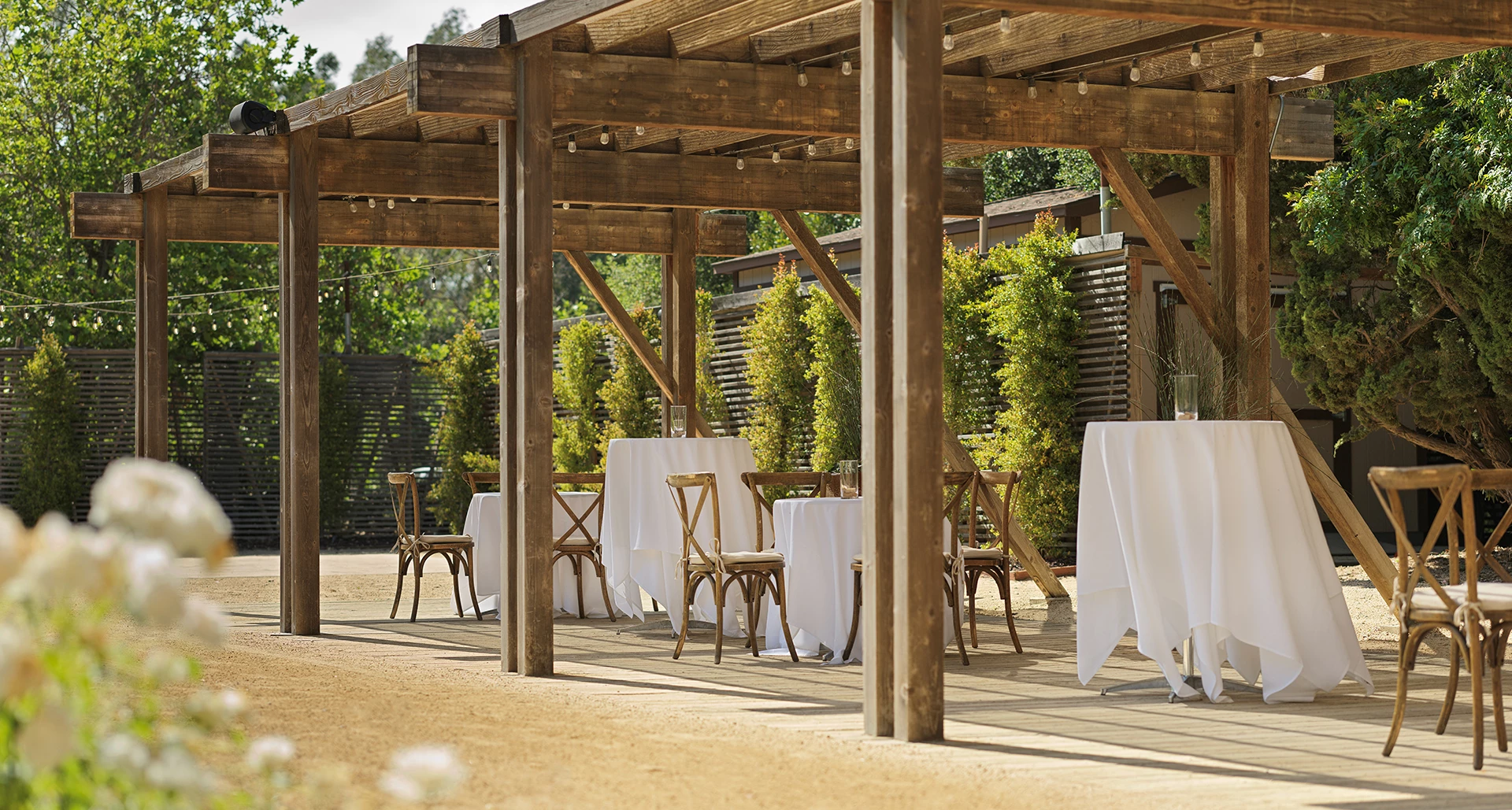 a table and chairs under a wooden structure