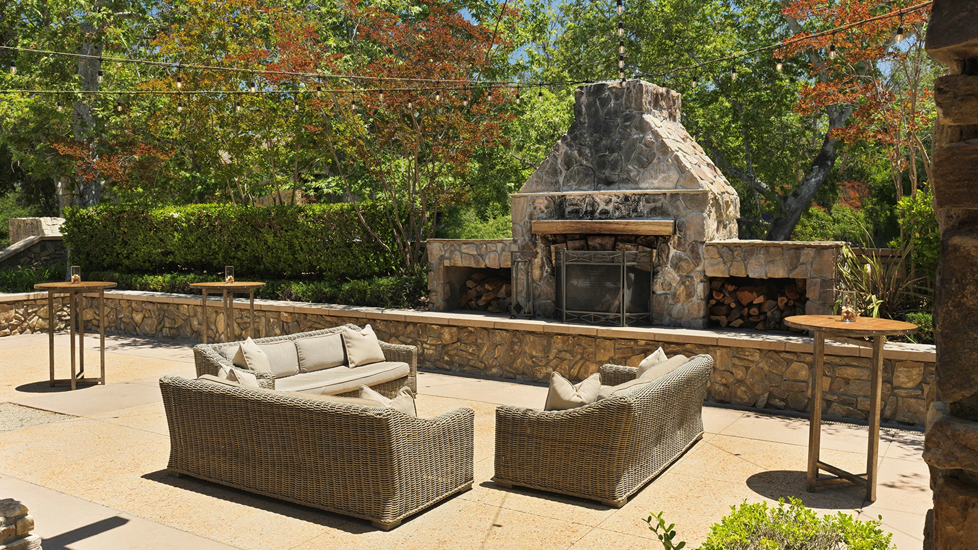 a patio with a stone fireplace and furniture