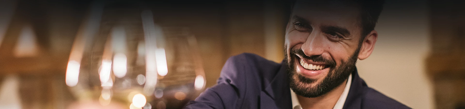 business man holding his wine glass up for a cheers while smiling