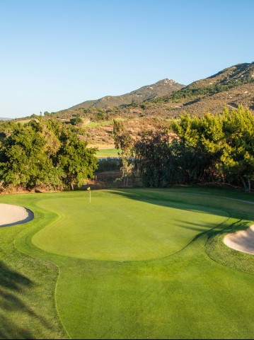 a golf course with sand bunkers and trees