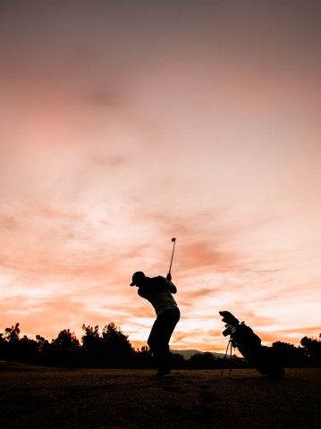 a person swinging a golf club