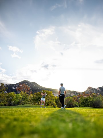 a man and woman standing on grass