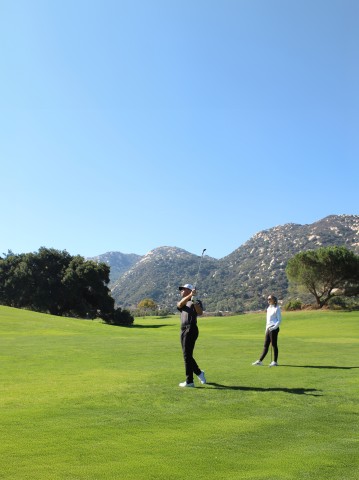 a man swinging a golf club on a golf course