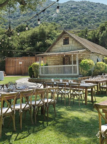 a group of tables and chairs outside a house