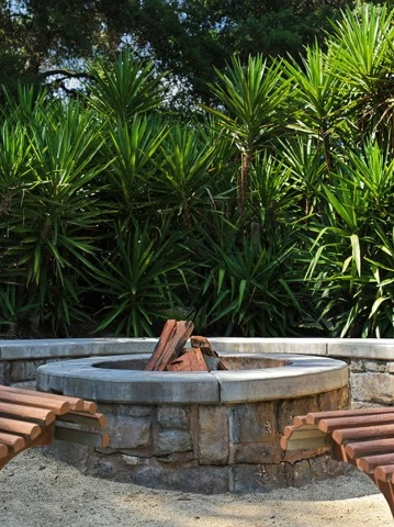 a fire pit with benches in the background