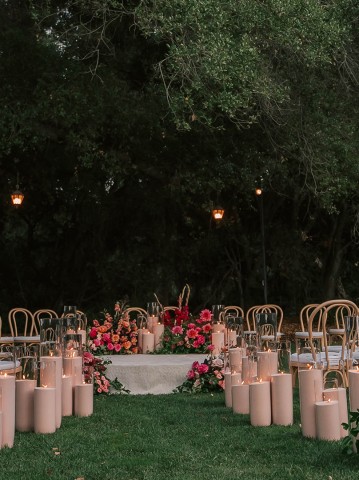 a group of chairs and tables with candles and flowers