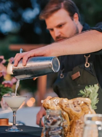 a man pouring liquid into a glass