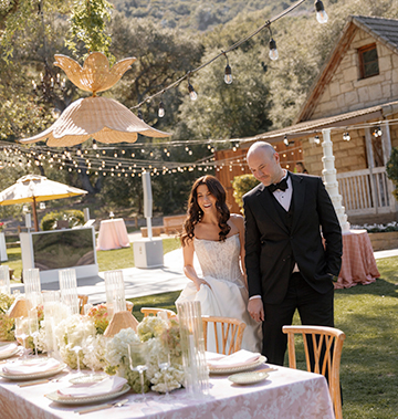a man and woman standing next to a table