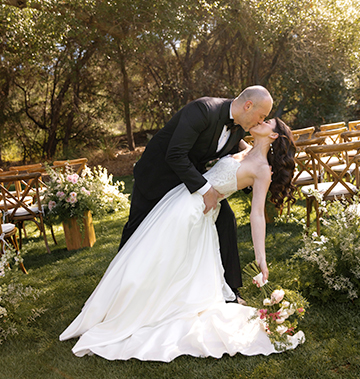 a man and woman kissing in a garden