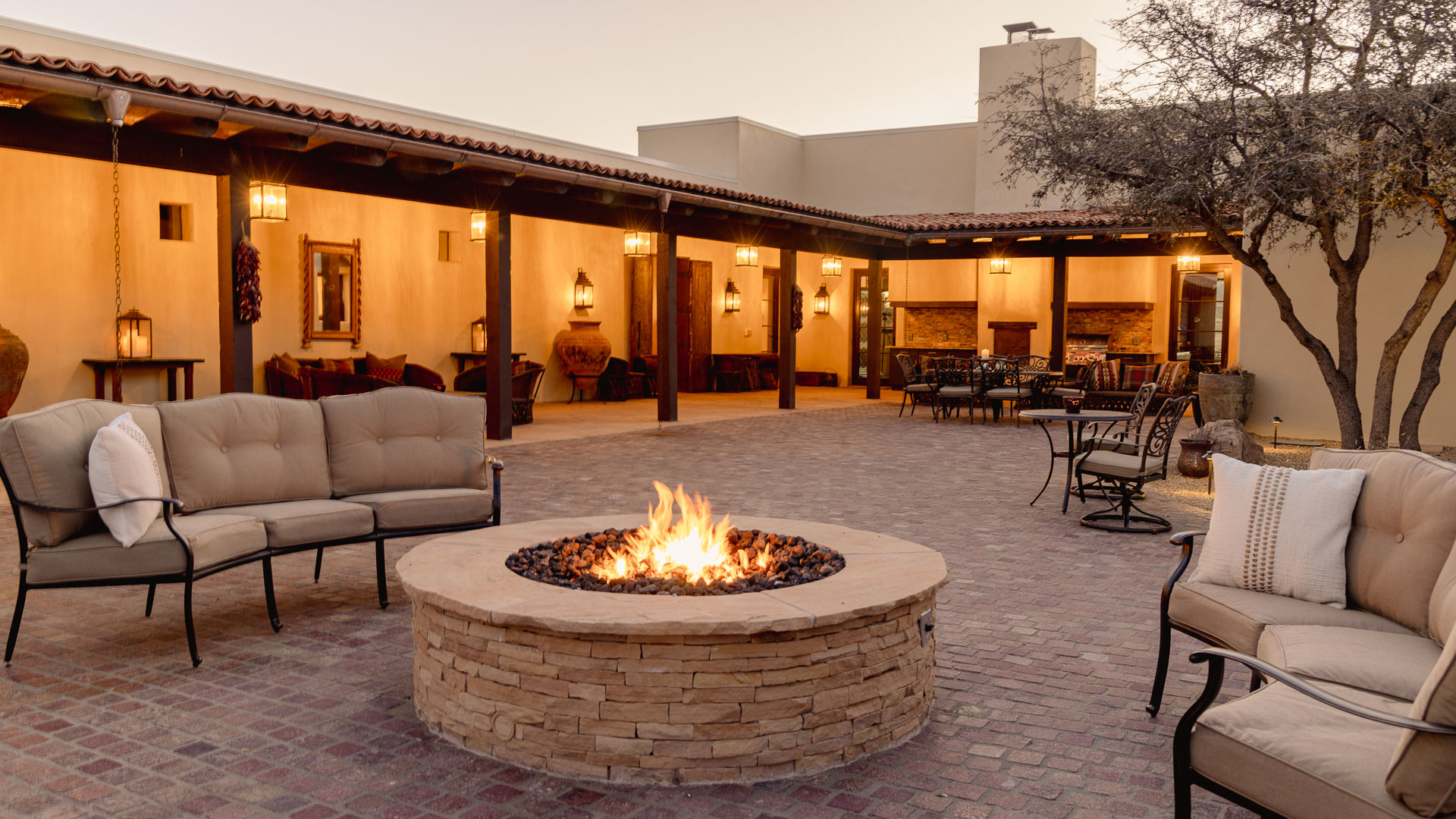a fire pit with chairs and tables in the back