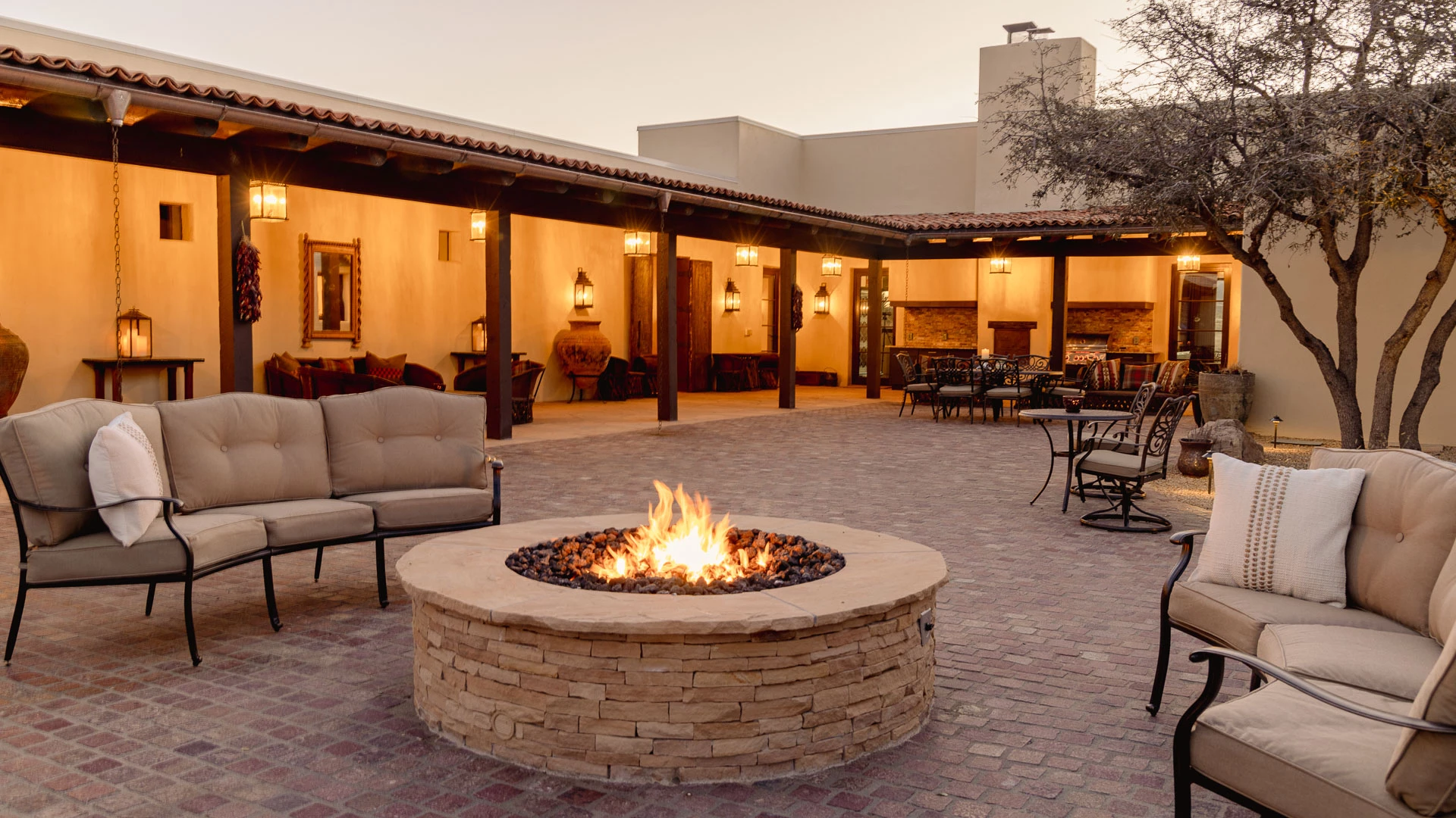 a fire pit with chairs and tables in the back