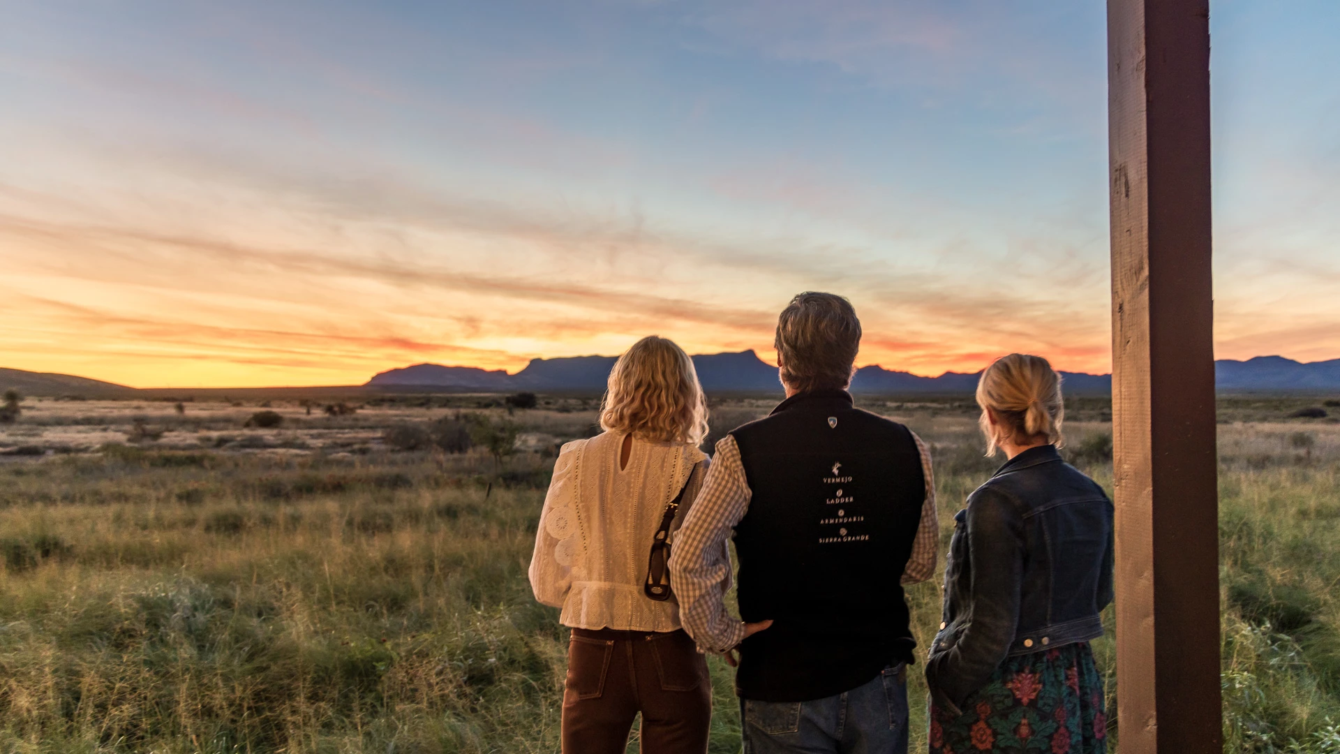 a group of people looking at a sunset