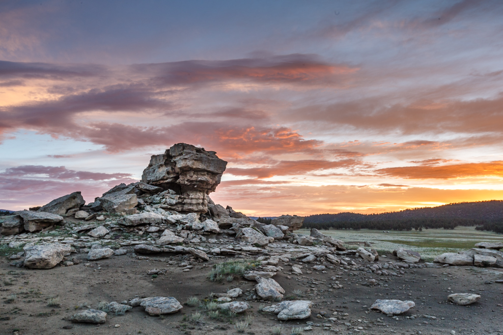 a large rock pile with a sunset in the background