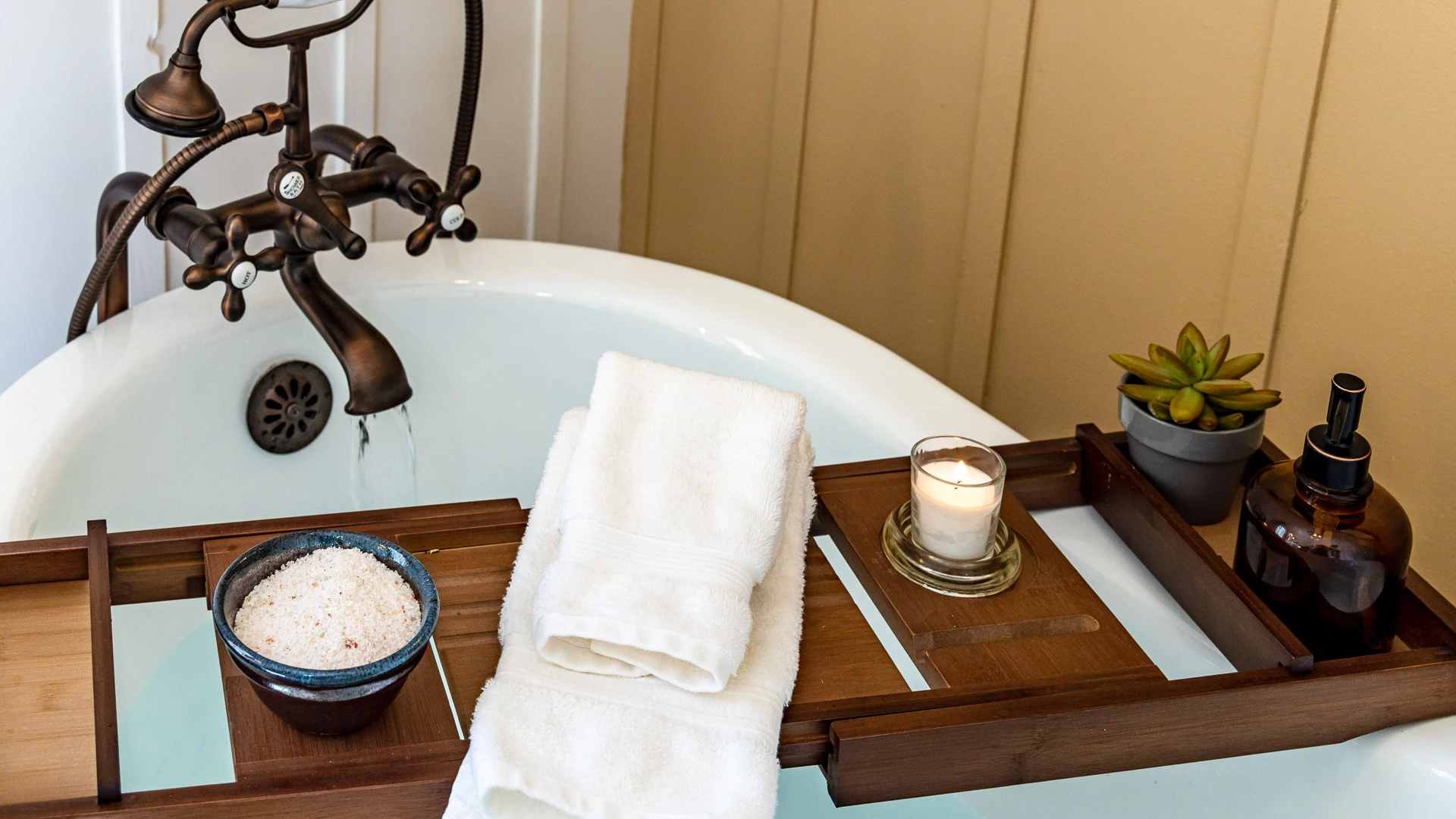 a bathtub with a candle and towels