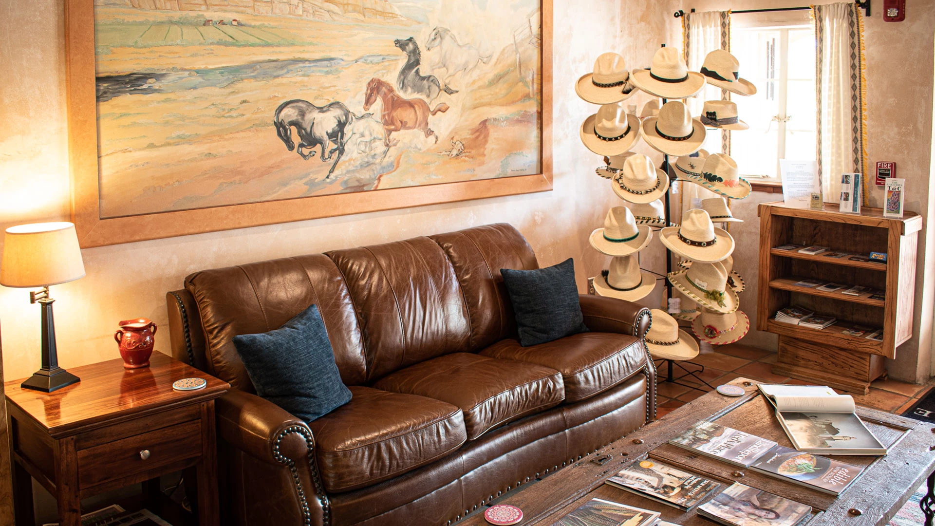 a couch with pillows and a hat display in a room