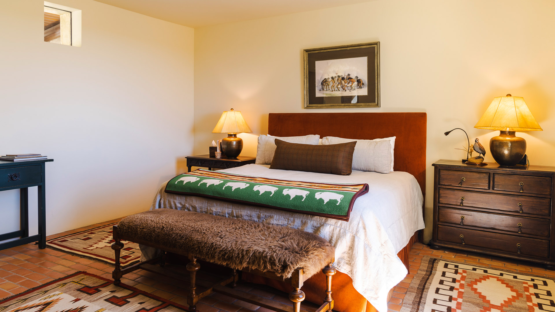 a bed with a bench and lamp
