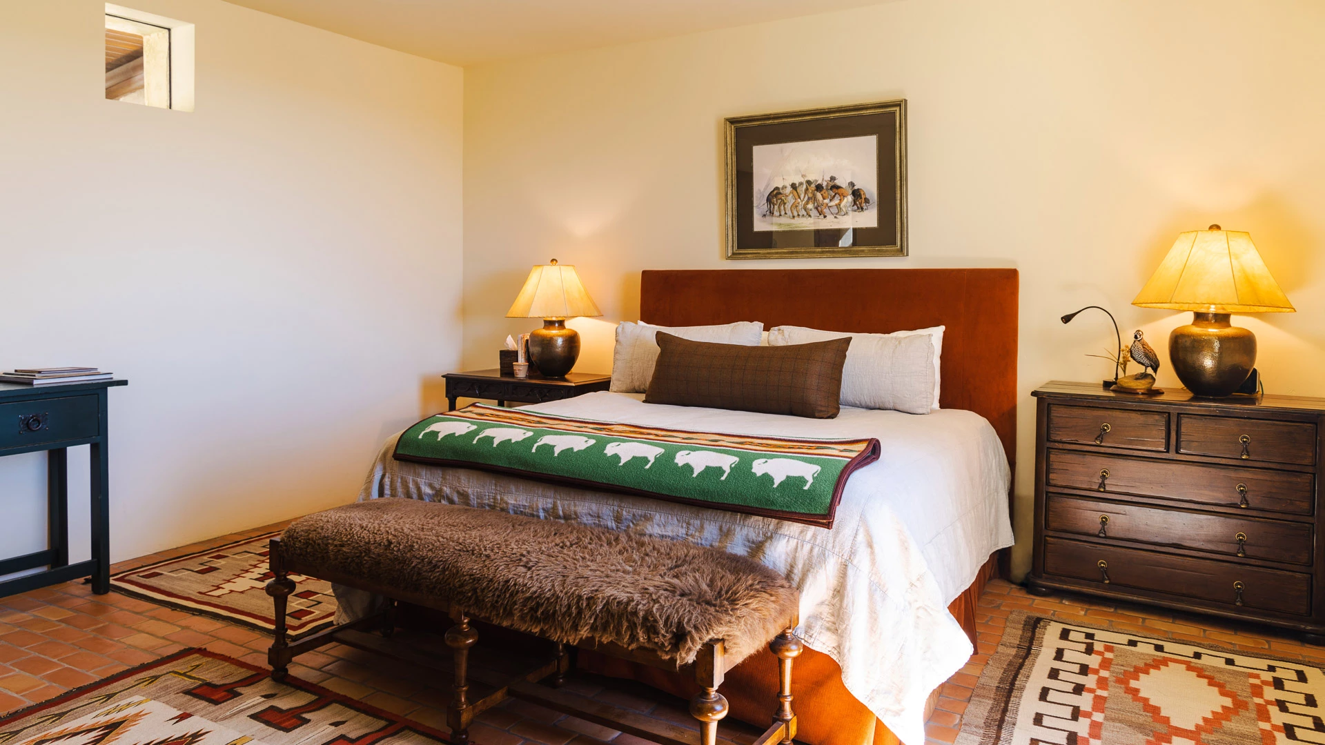 a bed with a bench and lamp