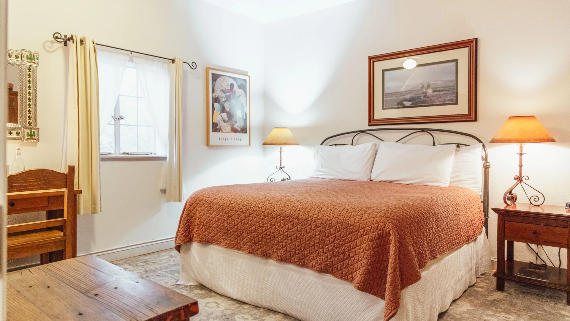 a bed with a lamp and picture on the wall